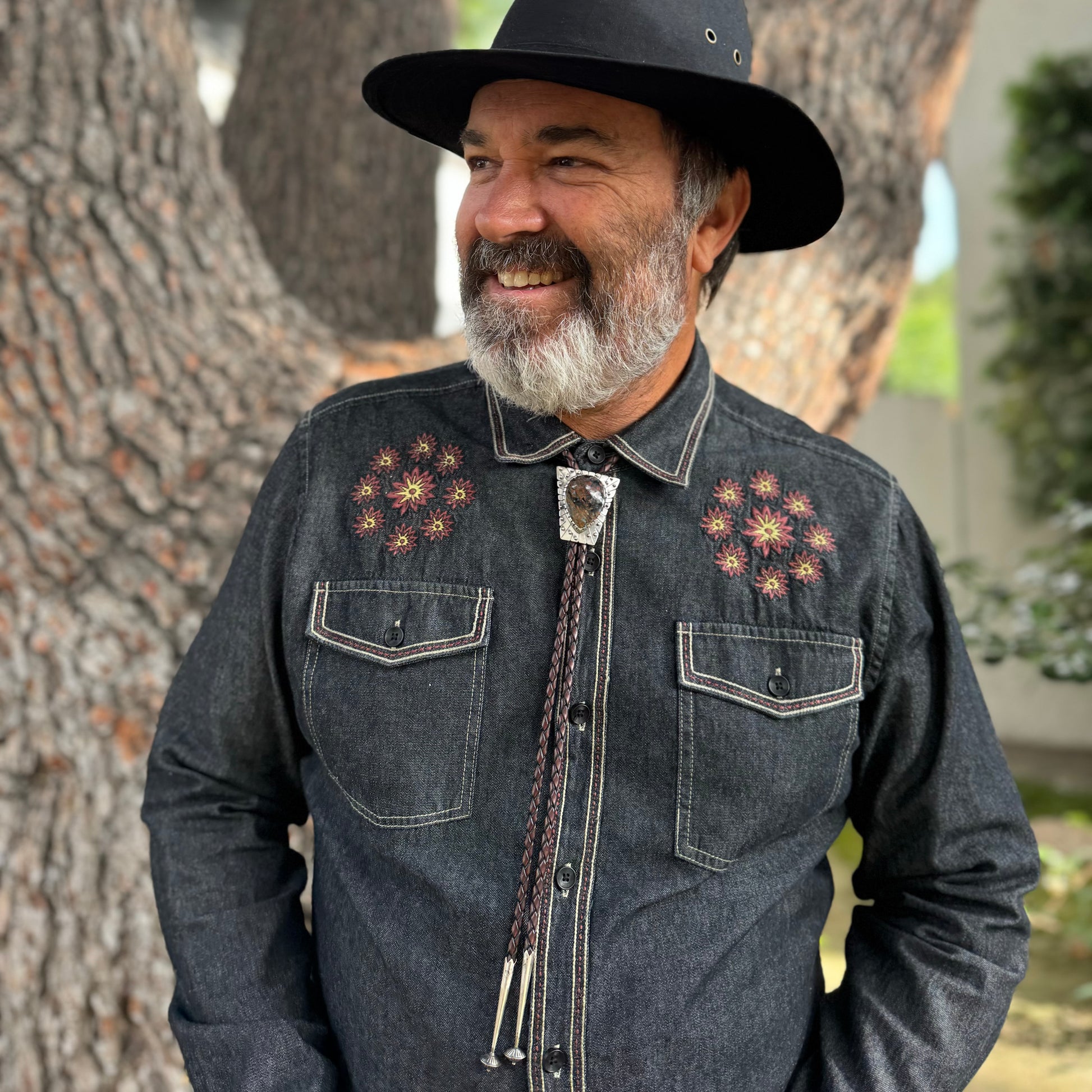 photo of a smiling bearded man wearing unique silver pietersite bolo tie