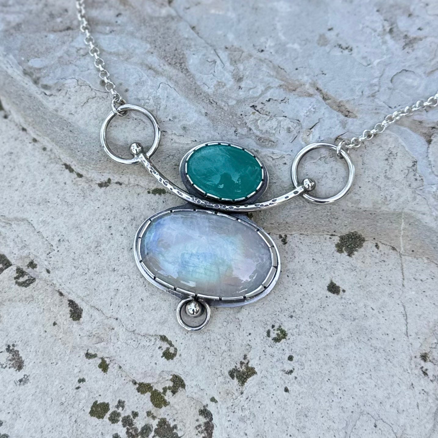 Necklace with two oval stones on a textured surface