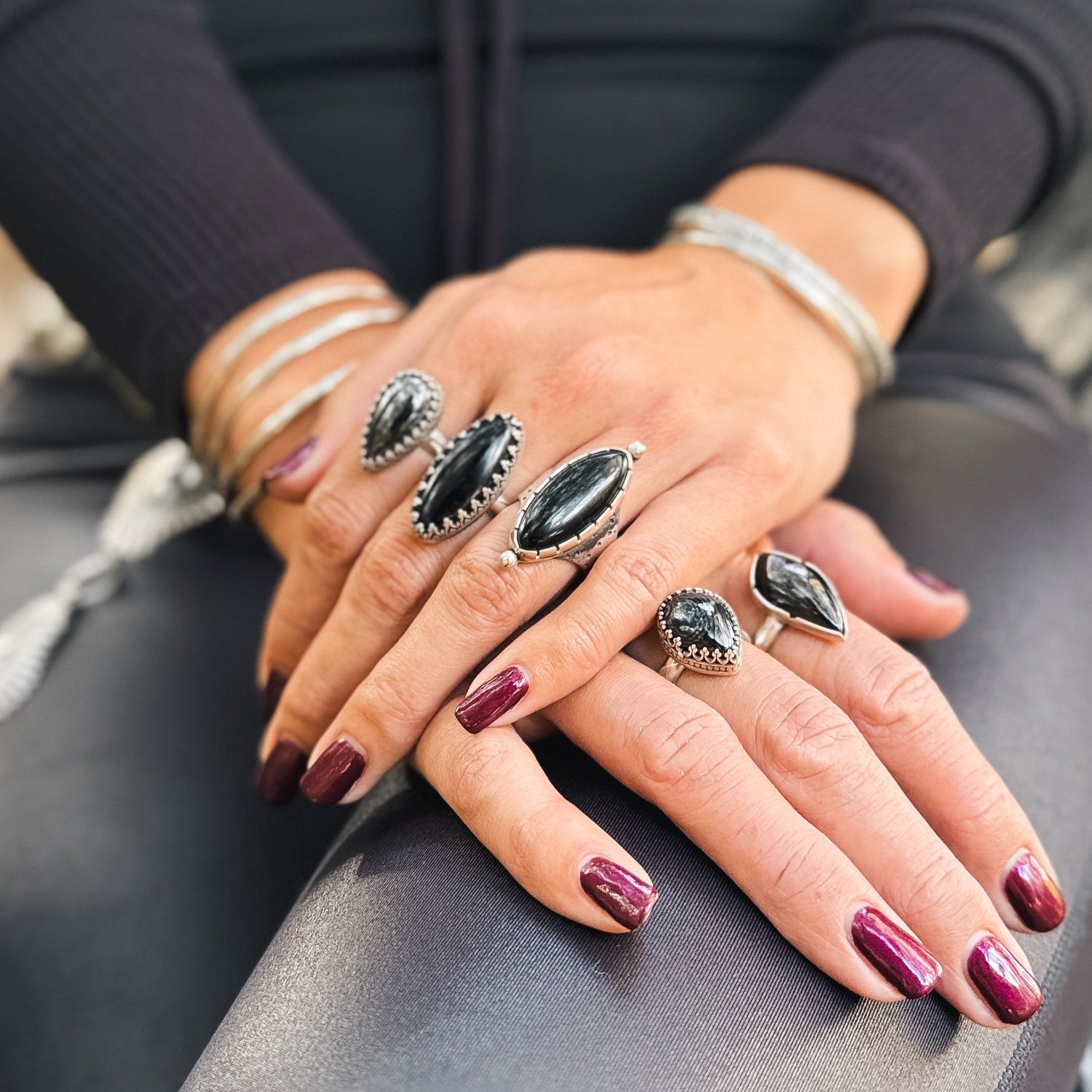 photo of a woman's hands wearing enchanted handmade sterling silver rings and bracelets